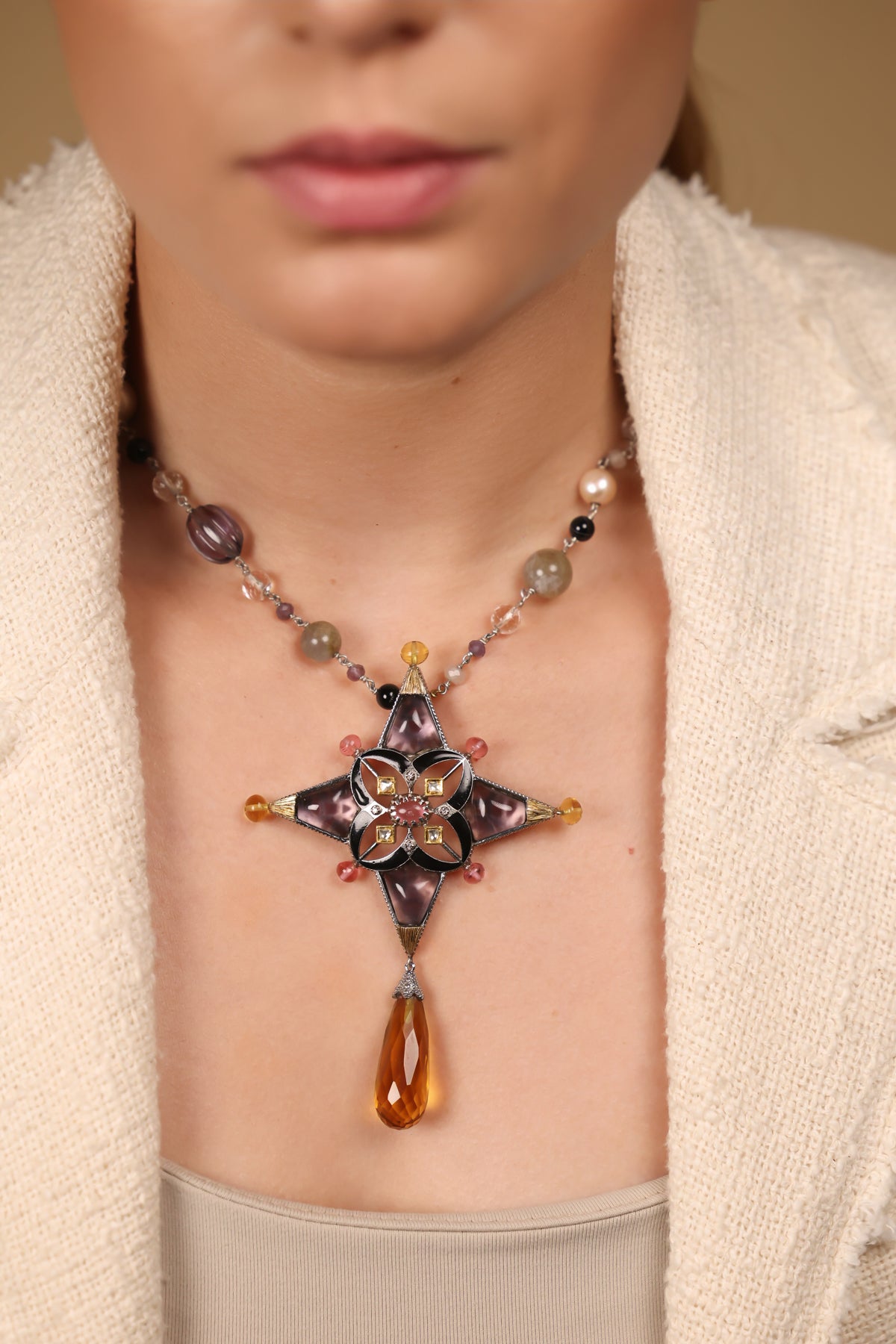 Close-up of the four-pointed star pendant on the Aashka Necklace showing the rose crystal and amethyst crystal setting