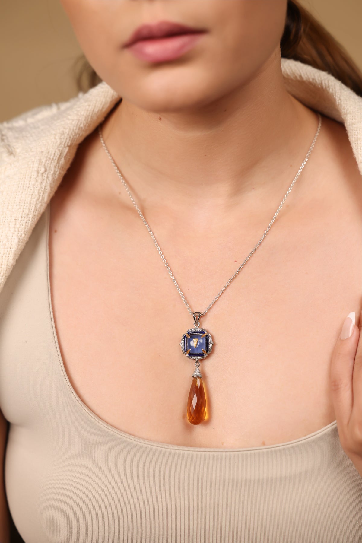 Close-up of hand-painted blue enamel and diamond accents on the Rumi Petit Pendant