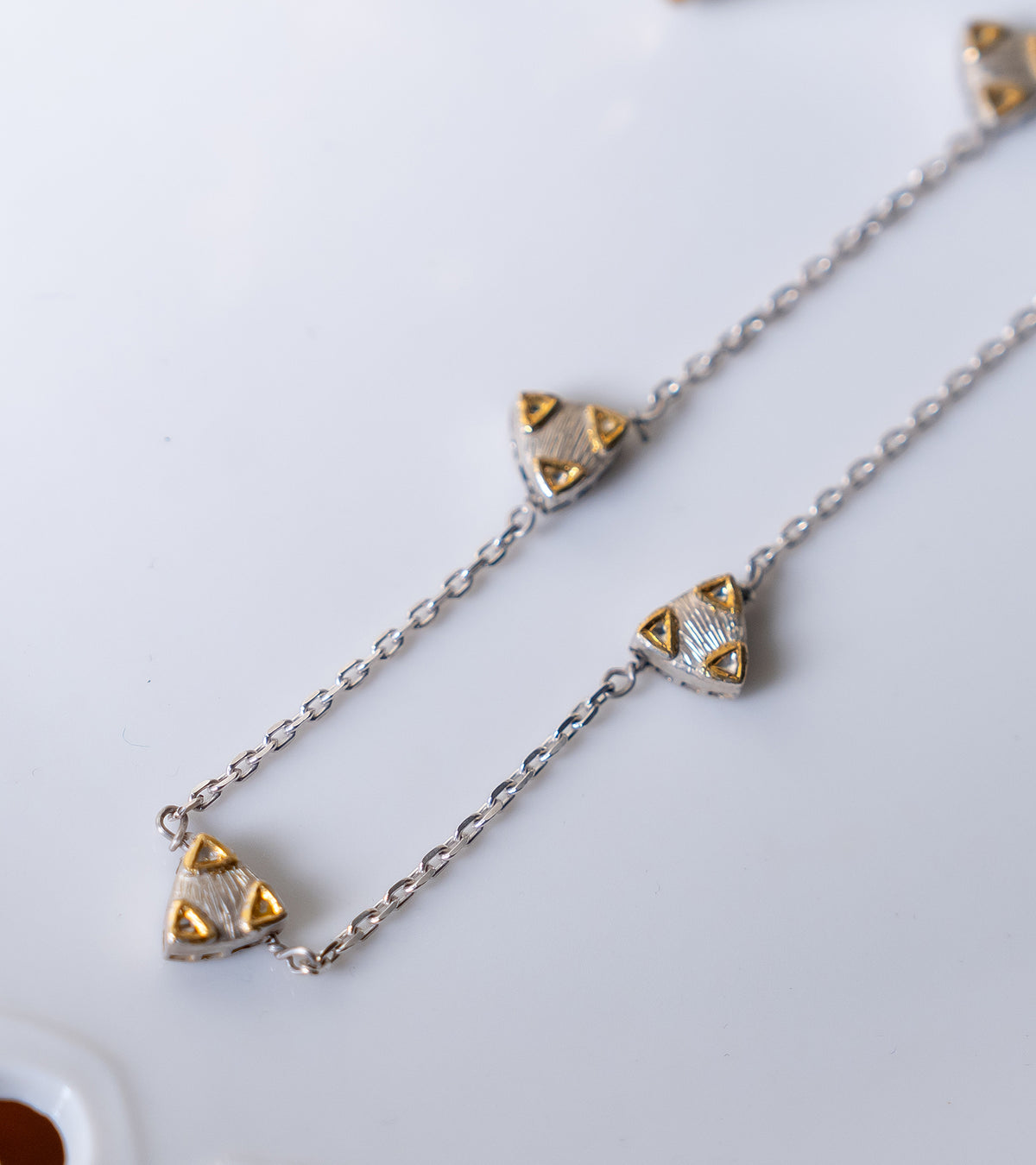 Close-up of the trillion Polki charms and silver chain detailing on the Zee Necklace