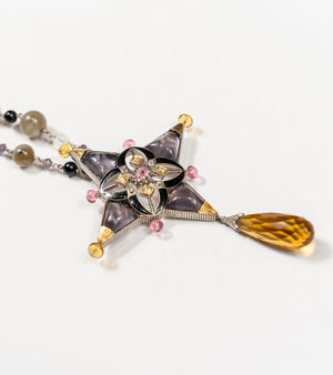 Aashka Necklace with a four-pointed star pendant in rose crystal and amethyst crystal, black enamel detailing, on a beaded pearl and natural stone chain