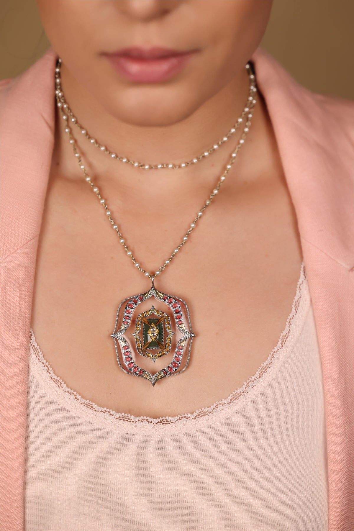 Close-up of the architectural silver pendant on the Amara Necklace, set with clear quartz, aventurine, citrine, and tourmaline