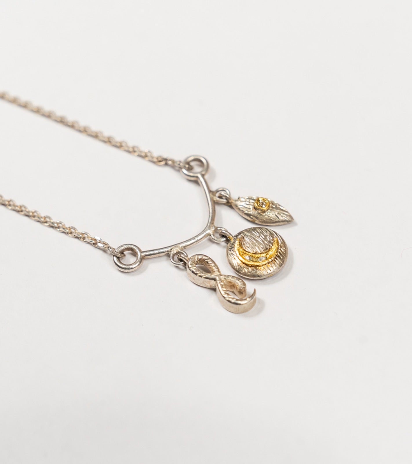 Ari Necklace with infinity, evil eye, and crescent charms in 22K Kundan gold with sterling silver and Polki diamonds