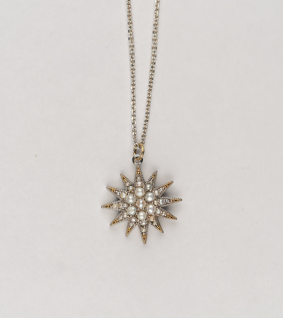 Detail of the Japanese pearls set within the Nova Necklace's silver starburst