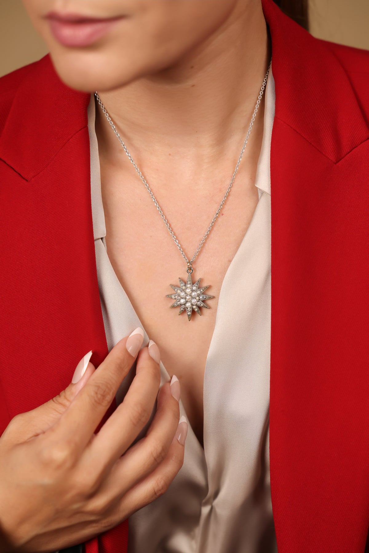 Close-up of the starburst design and Japanese pearl detailing on the Nova Necklace