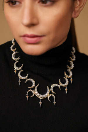 Close-up of the crescent silhouette and black enamel detailing on the Ragini Necklace