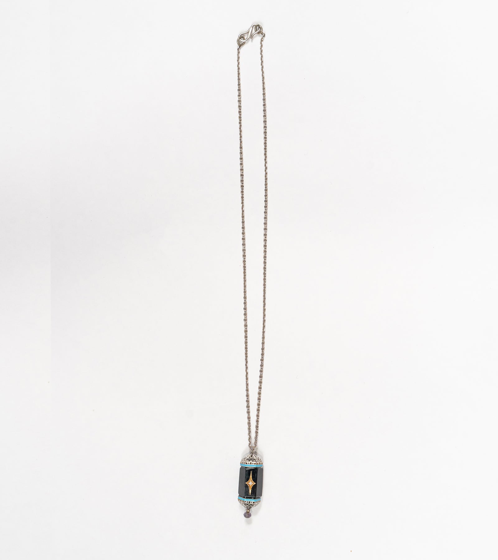 Detail of the hand-painted turquoise enamel accent on the Sirius Pendant
