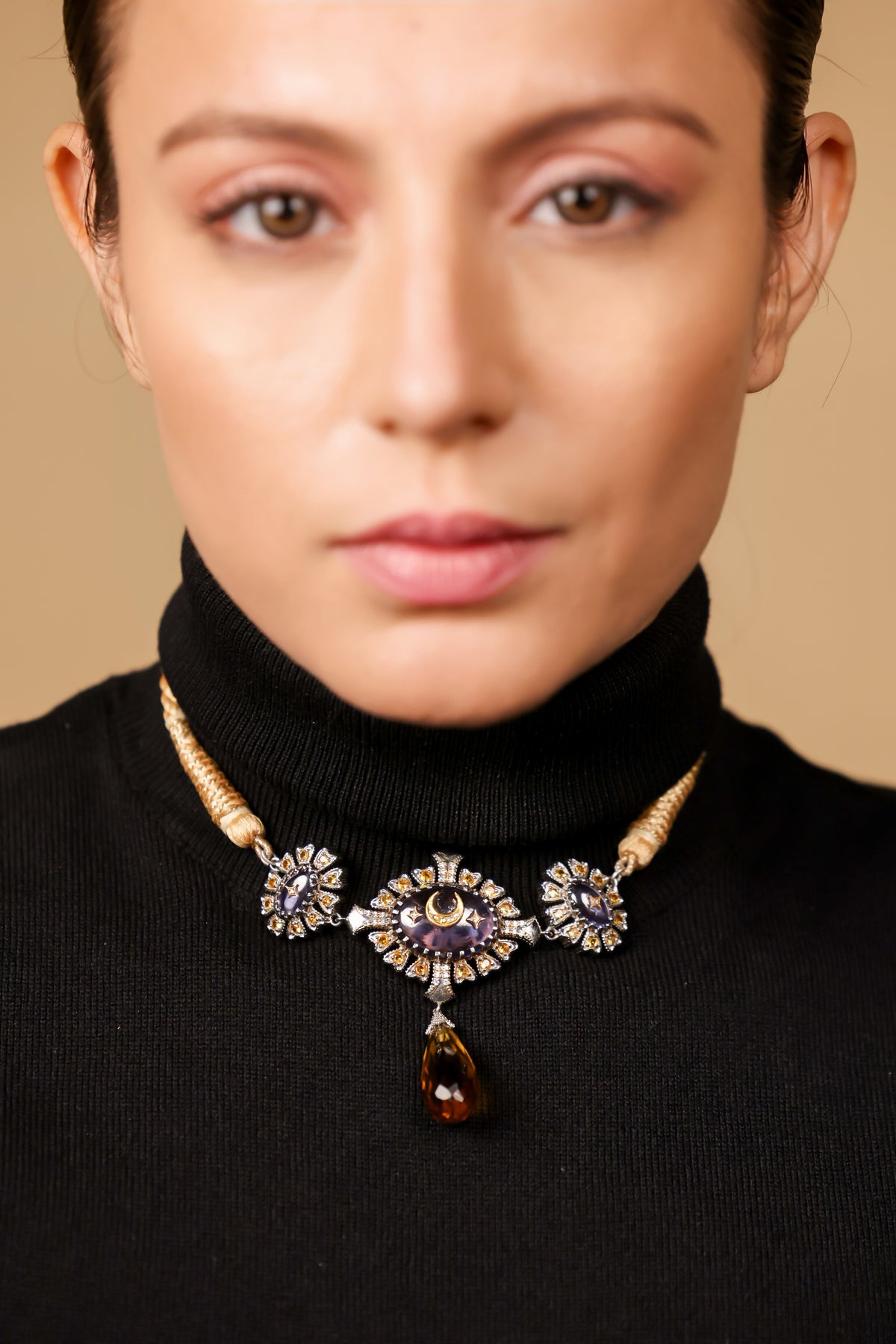 Close-up of the crescent moon and topaz drop finishing on the Virja Necklace