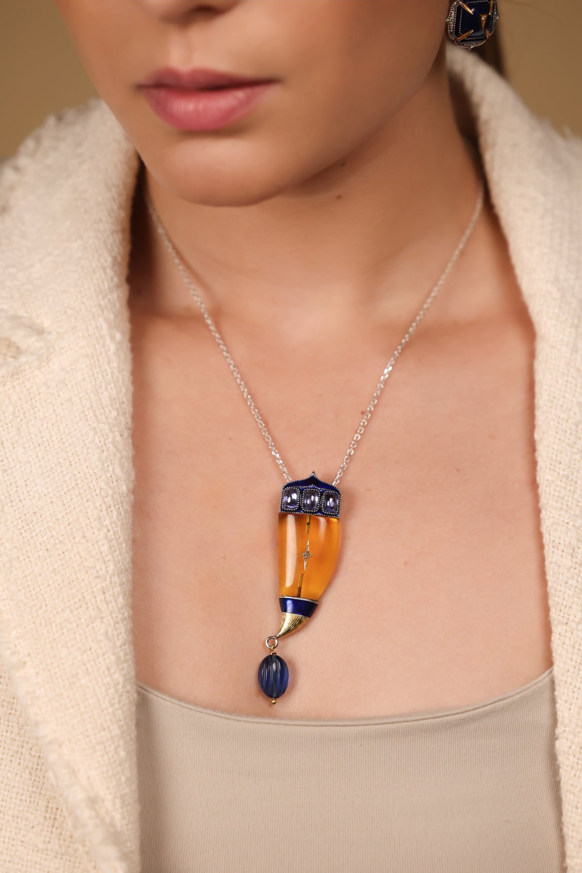 Vita Brooch Pendant worn as a pendant on a long chain with crisp tailoring